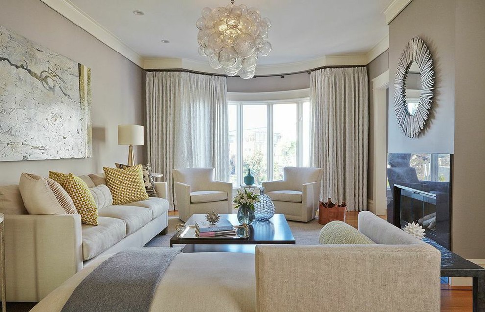 This is an example of a medium sized traditional formal enclosed living room in San Francisco with grey walls, medium hardwood flooring, a standard fireplace, a stone fireplace surround and no tv.