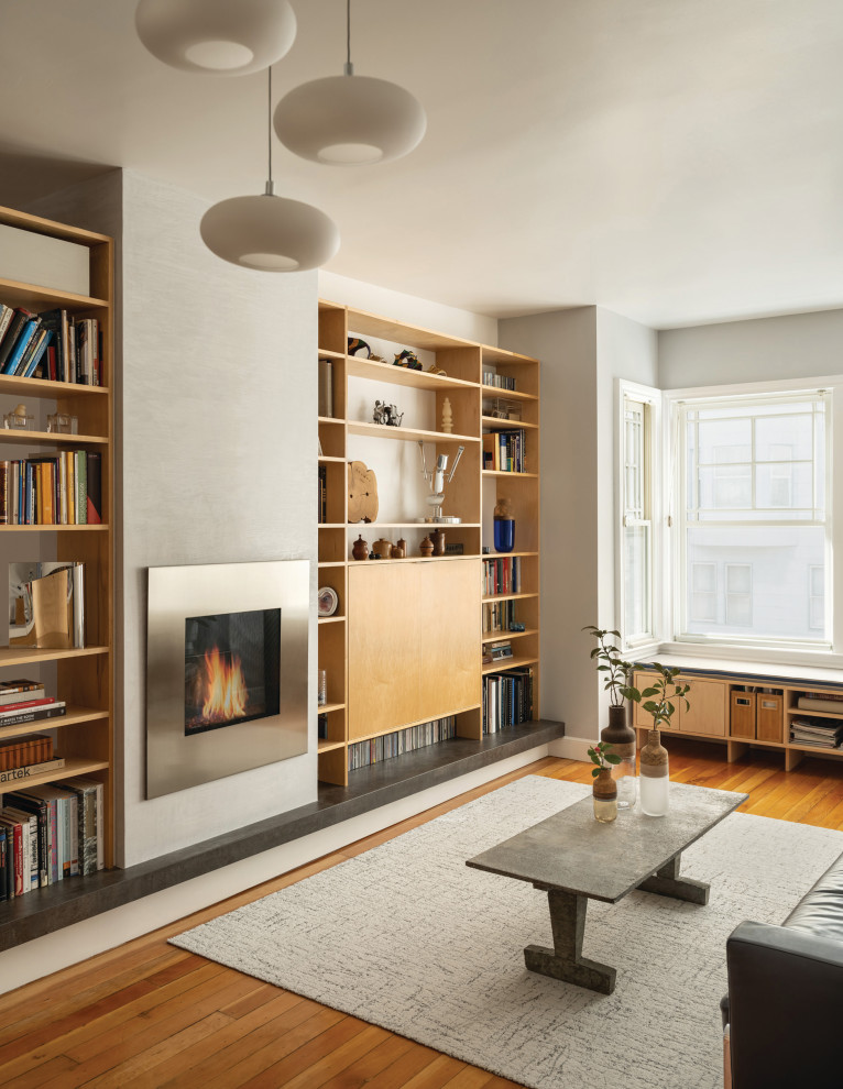 Стильный дизайн: гостиная комната в современном стиле с серыми стенами, паркетным полом среднего тона, стандартным камином и коричневым полом - последний тренд
