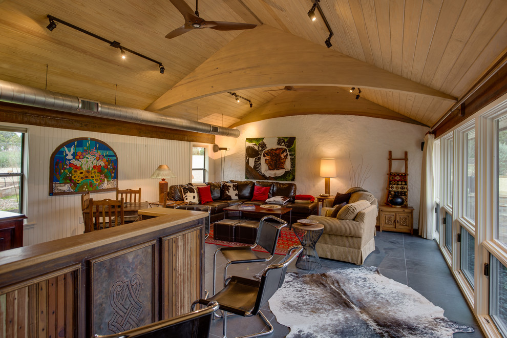 Mittelgroßes, Offenes Rustikales Wohnzimmer ohne Kamin mit Hausbar, weißer Wandfarbe, Schieferboden, TV-Wand und grauem Boden in Austin
