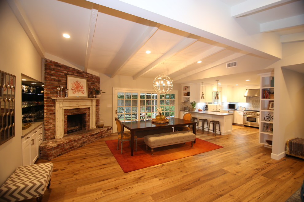 Example of a huge minimalist open concept medium tone wood floor and brown floor living room design in Los Angeles with beige walls, a corner fireplace, a brick fireplace, no tv and a bar