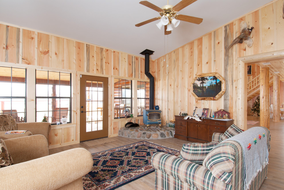 Esempio di un soggiorno stile rurale di medie dimensioni e aperto con sala formale, parquet chiaro, stufa a legna e nessuna TV