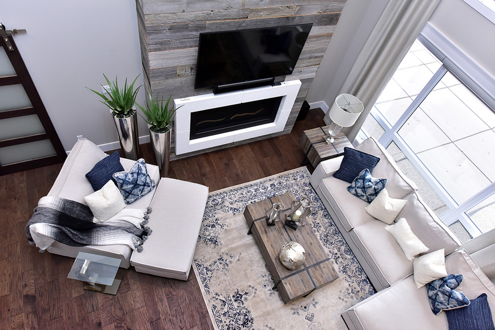Cette photo montre un grand salon tendance avec un manteau de cheminée en bois, un téléviseur fixé au mur et un sol marron.