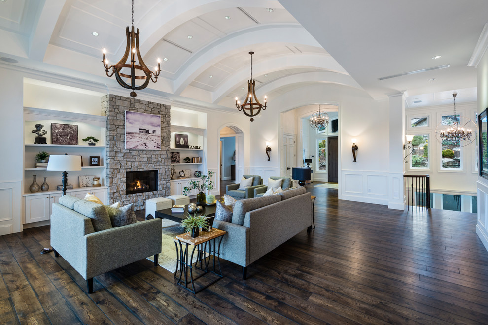 Example of a huge mountain style formal and open concept medium tone wood floor and brown floor living room design in Vancouver with white walls, a standard fireplace, a stone fireplace and no tv