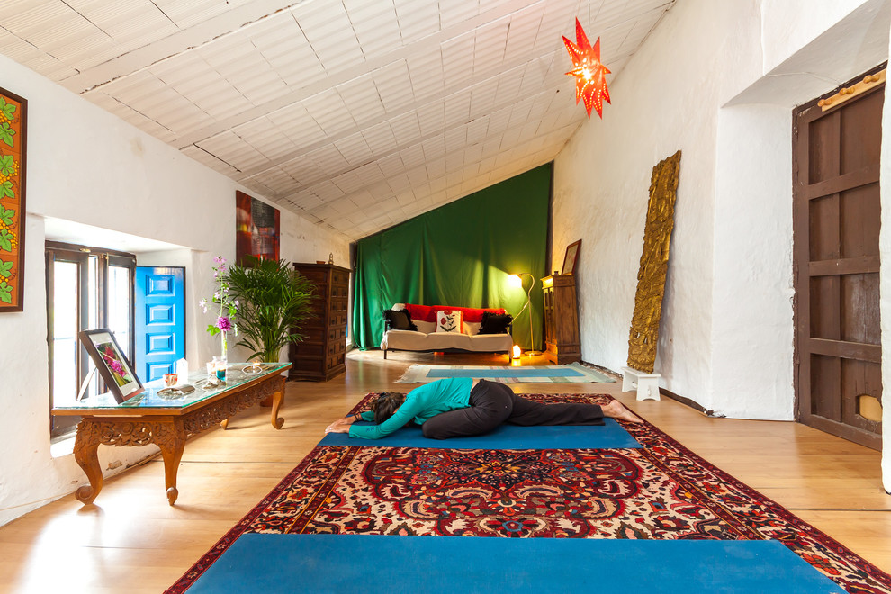 На фото: гостиная комната в средиземноморском стиле с белыми стенами и светлым паркетным полом