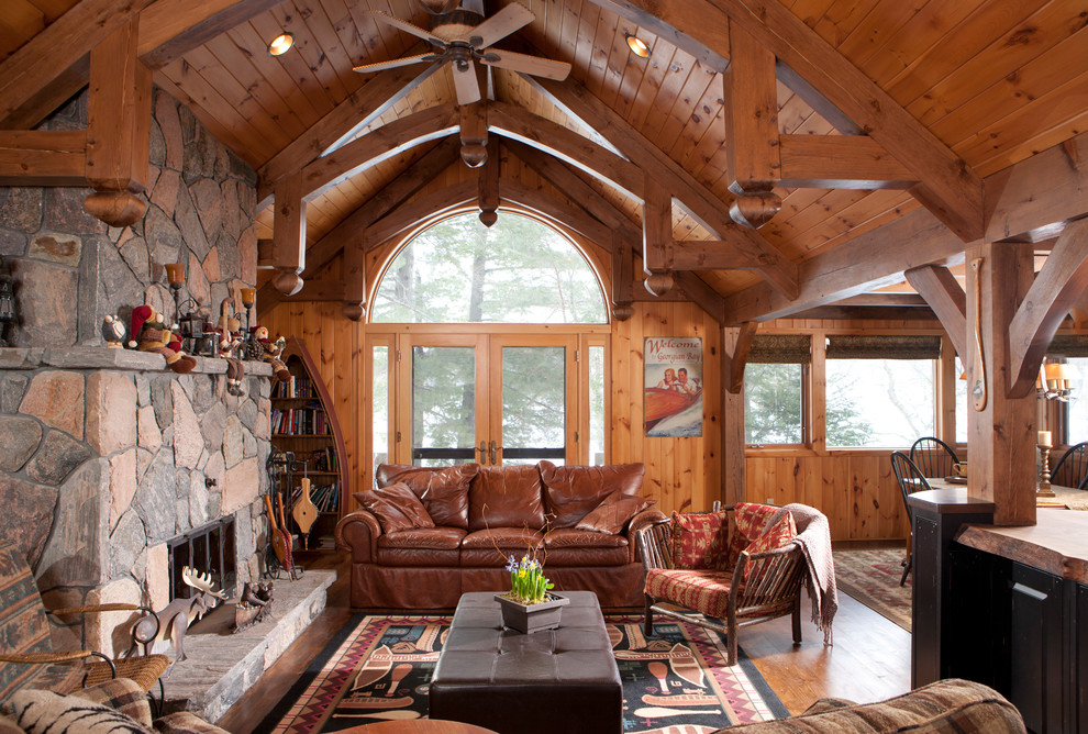 Inspiration for a mid-sized rustic open concept medium tone wood floor living room remodel in Toronto with a standard fireplace, a stone fireplace and no tv