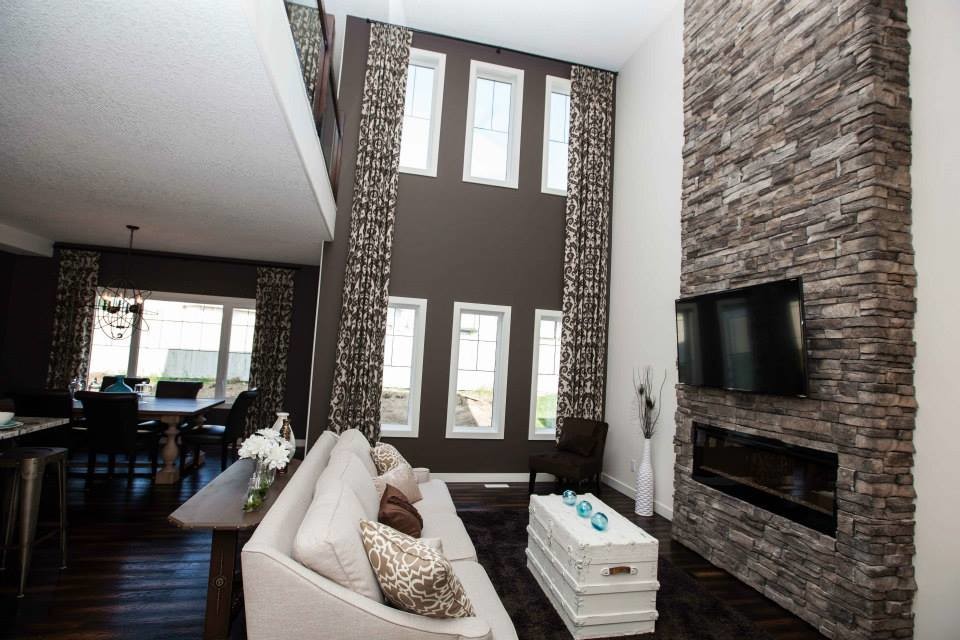Mid-sized mountain style formal and open concept dark wood floor living room photo in Edmonton with brown walls, a standard fireplace, a wall-mounted tv and a stone fireplace