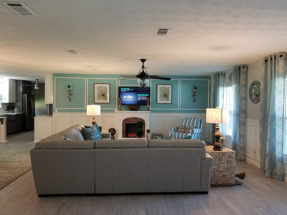Mittelgroßes, Offenes Country Wohnzimmer mit blauer Wandfarbe, hellem Holzboden, Kamin, Kaminumrandung aus Backstein und TV-Wand in Atlanta