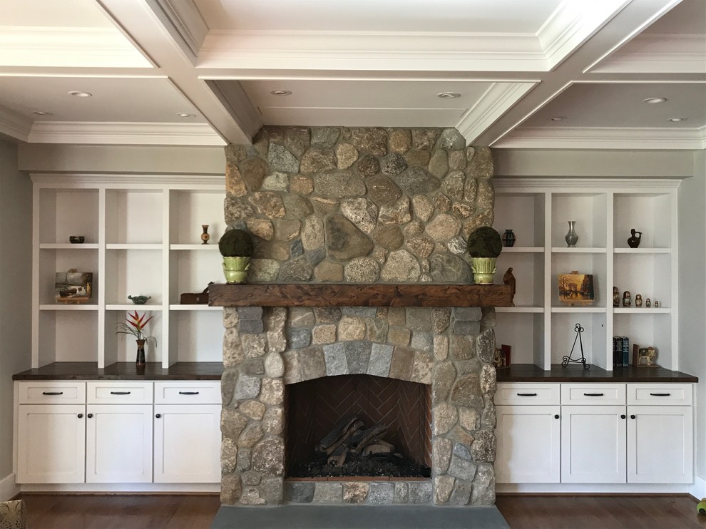 Inspiration for a mid-sized transitional open concept medium tone wood floor and brown floor living room library remodel in Other with gray walls, a standard fireplace, a stone fireplace and no tv
