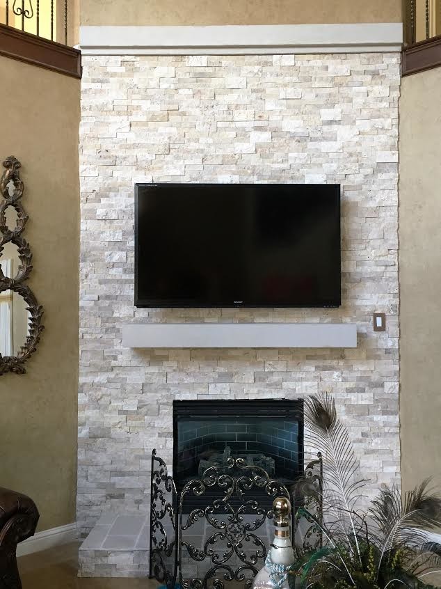 Свежая идея для дизайна: гостиная комната среднего размера в стиле рустика с коричневыми стенами, ковровым покрытием, угловым камином, фасадом камина из камня, телевизором на стене и коричневым полом - отличное фото интерьера