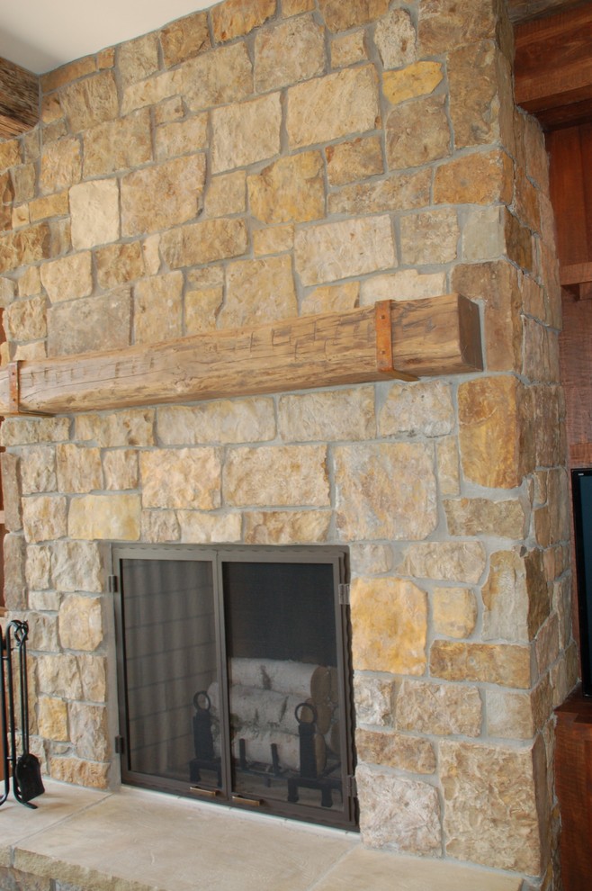 Cette photo montre un salon montagne avec une cheminée standard et un manteau de cheminée en pierre.