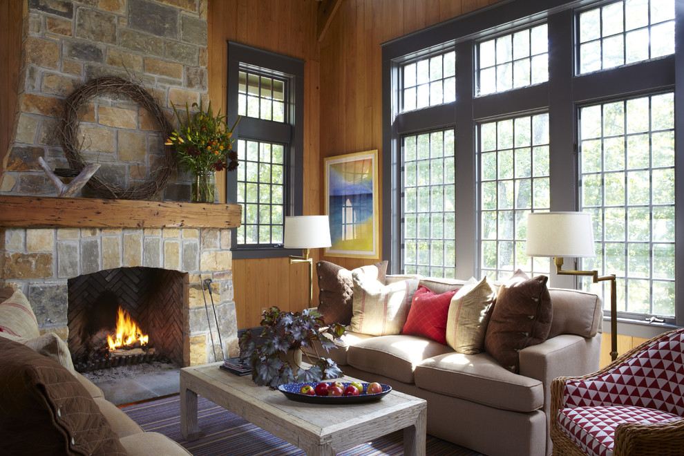 Example of a mountain style living room design in Birmingham with a standard fireplace, a stone fireplace and no tv