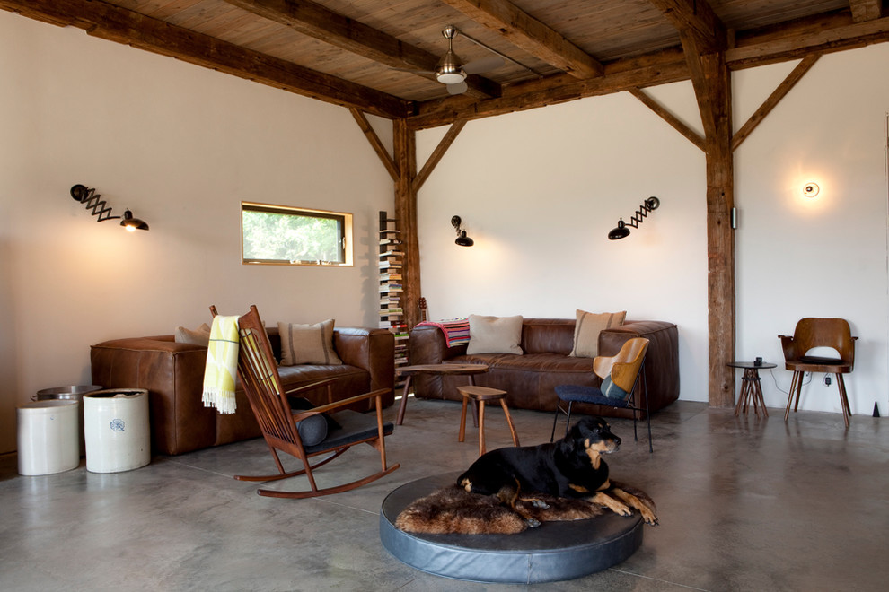 Esempio di un soggiorno stile rurale con pavimento in cemento