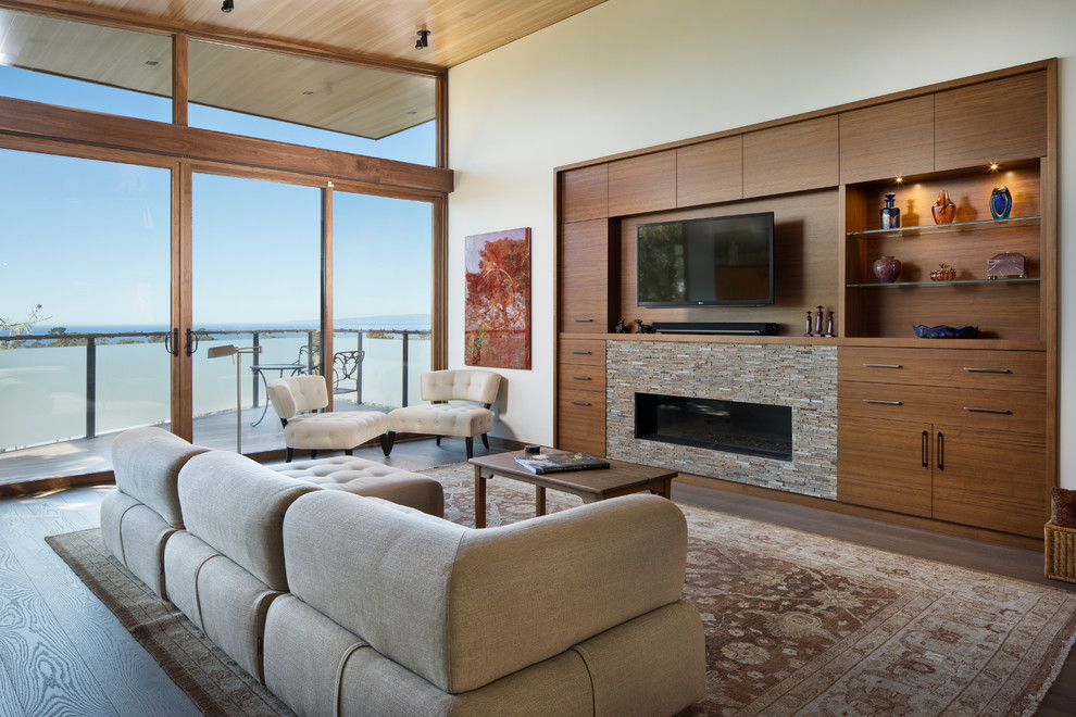 Example of a trendy formal and open concept medium tone wood floor and brown floor living room design in San Francisco with beige walls, a ribbon fireplace, a stone fireplace and a wall-mounted tv