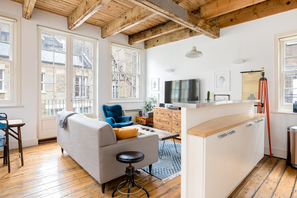 Esempio di un soggiorno minimal di medie dimensioni e aperto con pareti bianche, TV autoportante, pavimento in legno massello medio e pavimento marrone