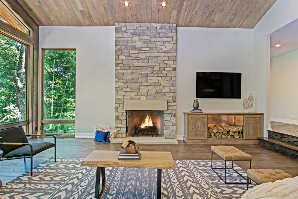 Photo of a large rustic open plan living room in Grand Rapids with medium hardwood flooring, a standard fireplace and a stone fireplace surround.