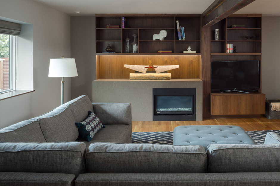 Offenes Country Wohnzimmer mit grauer Wandfarbe, braunem Holzboden, Kamin, Kaminumrandung aus Stein und freistehendem TV in Denver