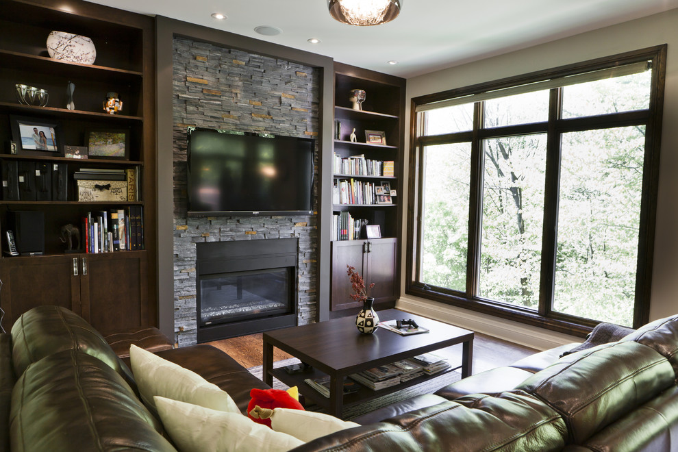 Идея дизайна: гостиная комната в современном стиле с стандартным камином и телевизором на стене