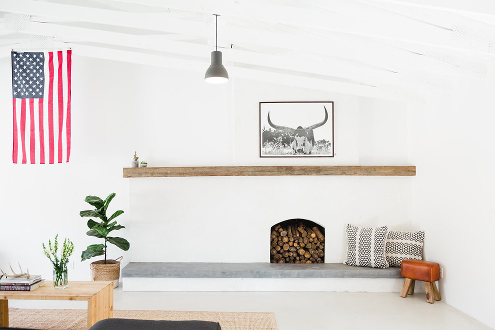 サンディエゴにあるお手頃価格の中くらいなサンタフェスタイルのおしゃれなLDK (白い壁、コンクリートの床、標準型暖炉、コンクリートの暖炉まわり) の写真