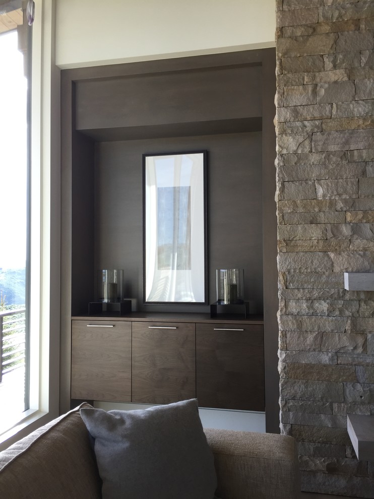 Idée de décoration pour un grand salon chalet ouvert avec un mur beige, parquet clair, une cheminée standard et un manteau de cheminée en pierre.