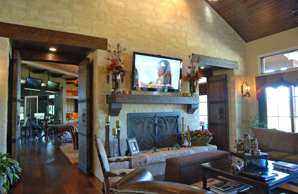 Living room - huge rustic open concept dark wood floor living room idea in Austin with beige walls, a standard fireplace and a wall-mounted tv