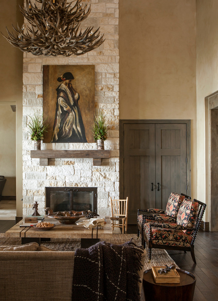 Imagen de salón rural sin televisor con paredes beige, todas las chimeneas y marco de chimenea de piedra