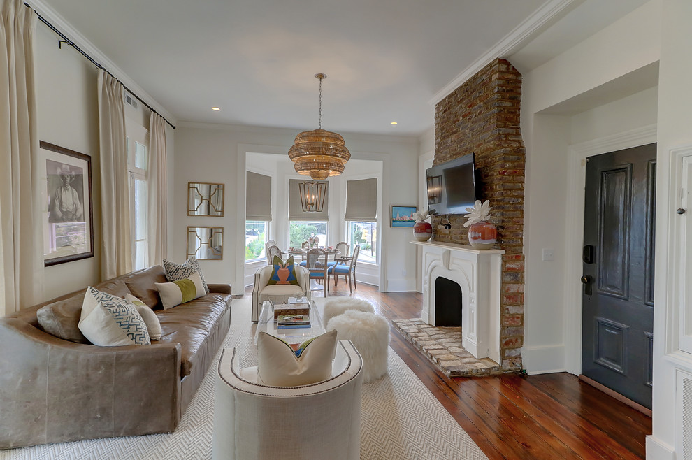 Living room - transitional enclosed dark wood floor and brown floor living room idea in Charleston with white walls, a standard fireplace, a plaster fireplace and a wall-mounted tv