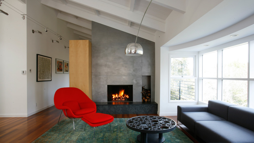Источник вдохновения для домашнего уюта: большая открытая гостиная комната в стиле ретро с белыми стенами, паркетным полом среднего тона, стандартным камином, фасадом камина из бетона и коричневым полом