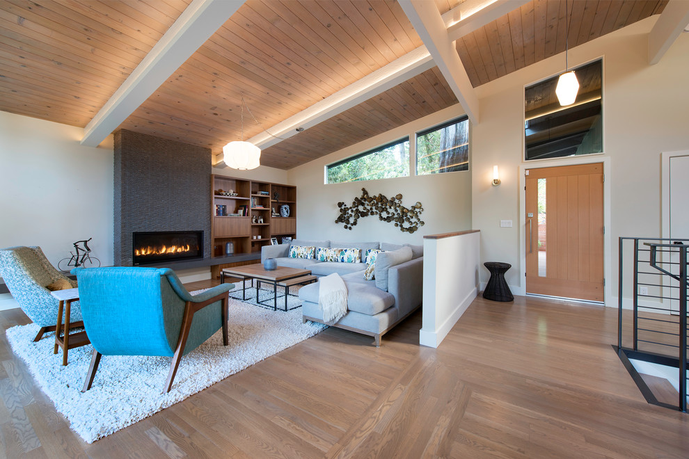 Immagine di un soggiorno minimalista aperto con pareti gialle, pavimento in legno massello medio, camino lineare Ribbon e nessuna TV