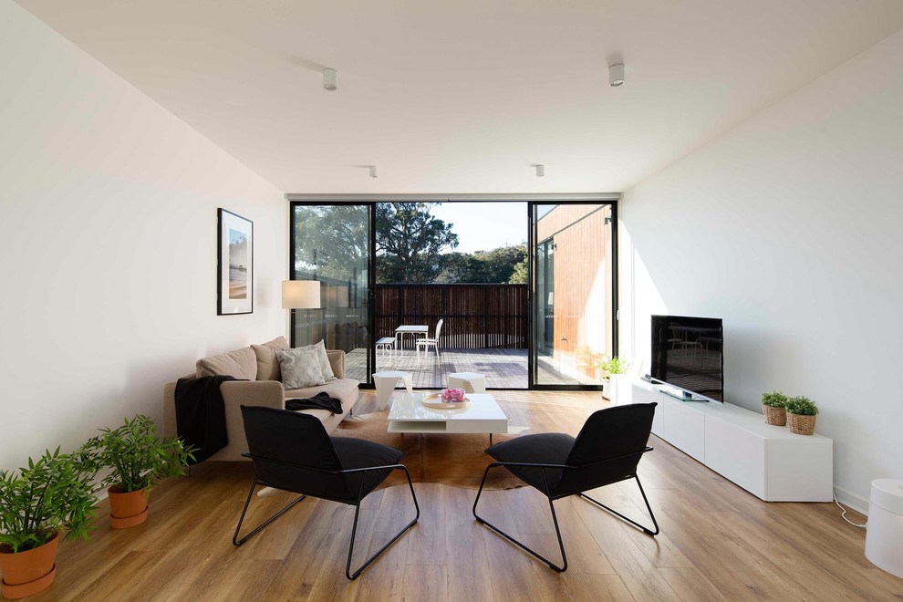 Photo of a scandi open plan living room in Melbourne with white walls, light hardwood flooring and a freestanding tv.
