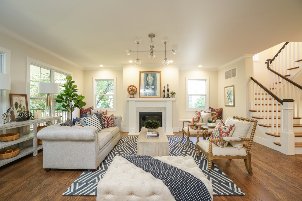 Offenes Klassisches Wohnzimmer mit beiger Wandfarbe, braunem Holzboden, Kamin und braunem Boden in St. Louis