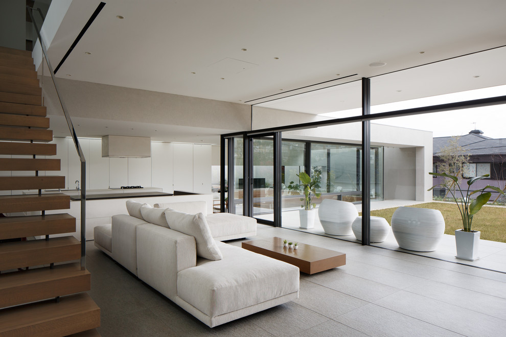 Ispirazione per un soggiorno minimalista aperto con pareti bianche, pavimento grigio, pavimento con piastrelle in ceramica e nessun camino