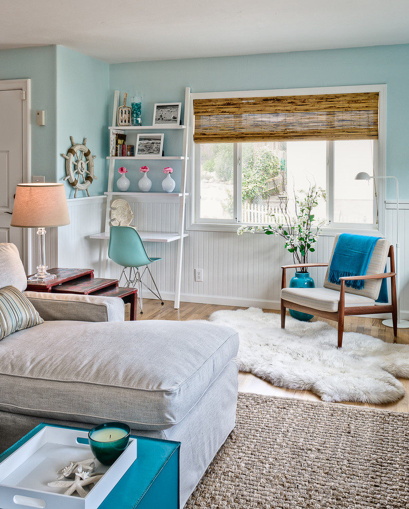 Example of a beach style open concept medium tone wood floor living room design in San Luis Obispo with blue walls