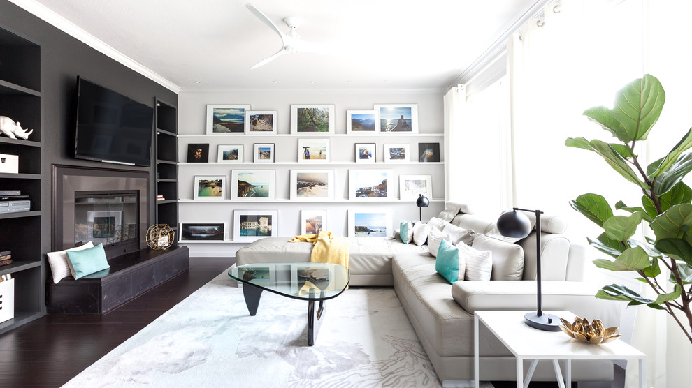 Example of a trendy formal dark wood floor living room design in Sacramento with black walls, a standard fireplace and a wall-mounted tv