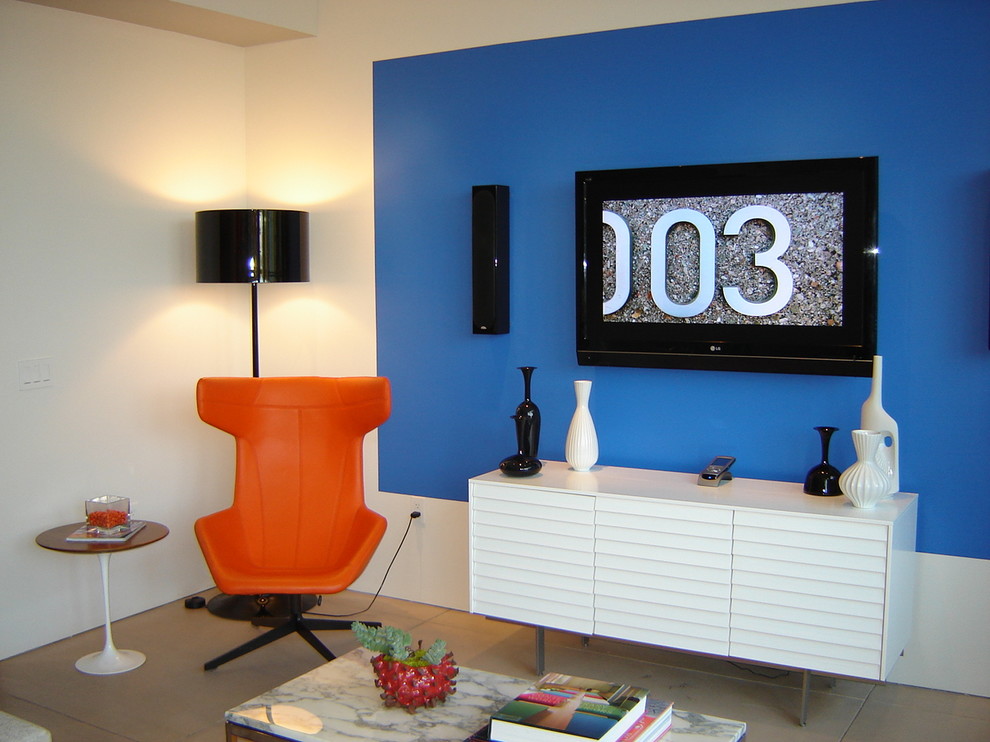 Foto di un grande soggiorno minimal aperto con pareti blu, pavimento in cemento, nessun camino e TV a parete