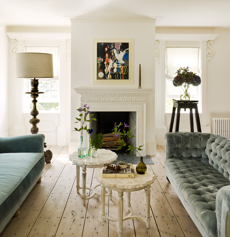 Example of a mid-sized classic formal and enclosed light wood floor and beige floor living room design in New York with white walls, a standard fireplace, a plaster fireplace and no tv