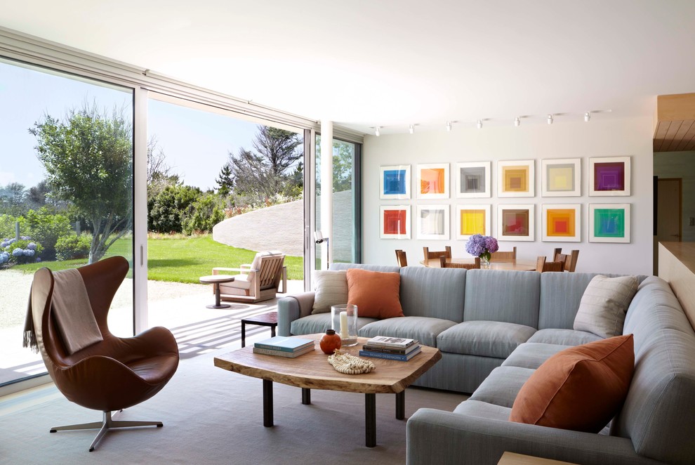 Photo of a large contemporary formal open plan living room in New York with white walls and a wall mounted tv.