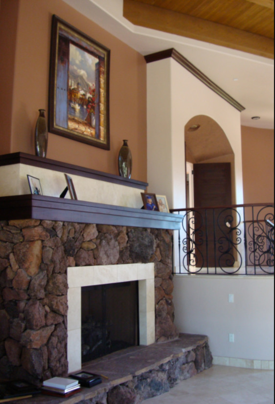 フェニックスにあるサンタフェスタイルのおしゃれなリビング (マルチカラーの壁、磁器タイルの床、標準型暖炉、石材の暖炉まわり、ベージュの床) の写真