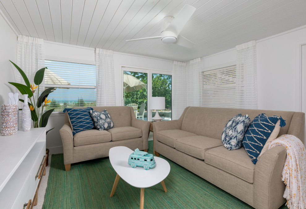 Esempio di un piccolo soggiorno stile marino aperto con pareti bianche, pavimento con piastrelle in ceramica, TV a parete e soffitto in legno