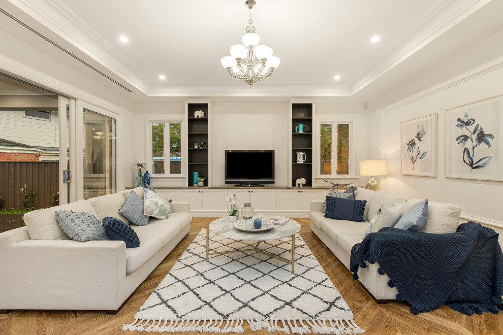 Abgetrenntes Klassisches Wohnzimmer ohne Kamin mit weißer Wandfarbe, braunem Holzboden, freistehendem TV, braunem Boden und Wandpaneelen in Melbourne