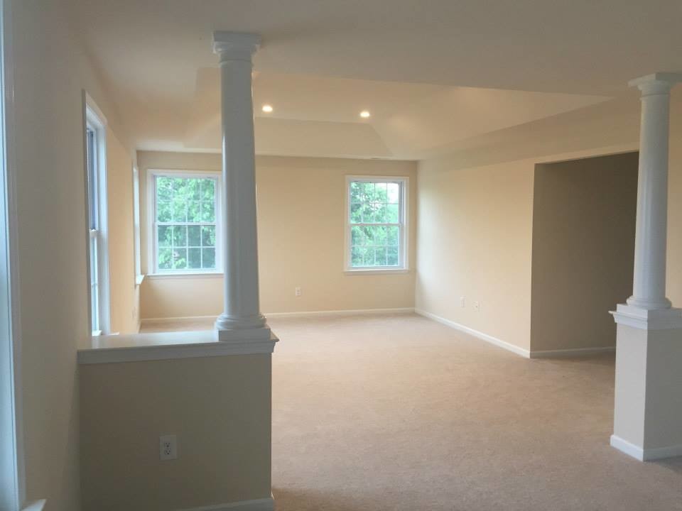 This is an example of a medium sized traditional formal open plan living room in Philadelphia with beige walls and carpet.