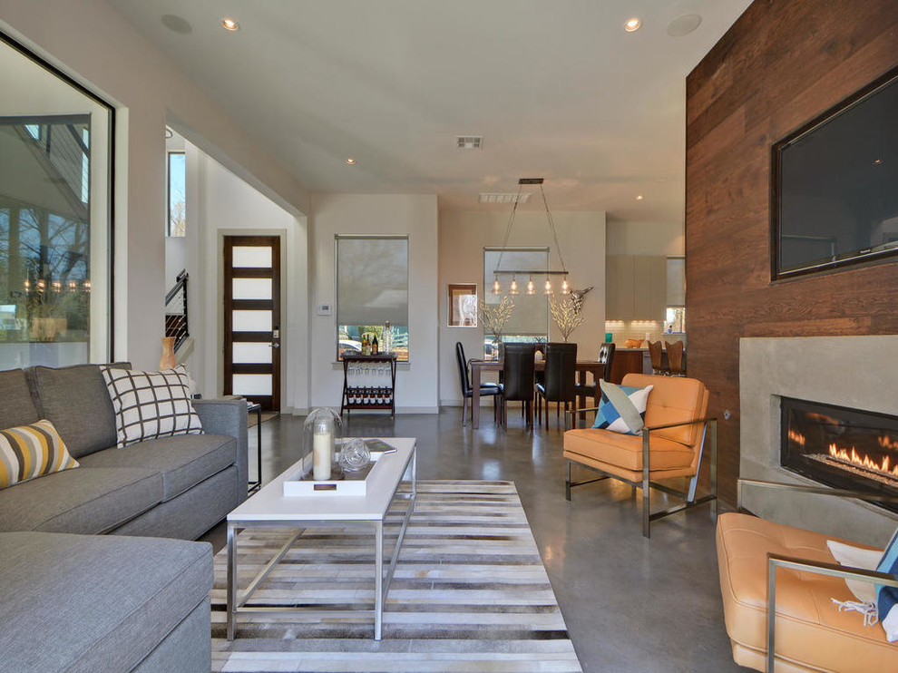 This is an example of a large contemporary formal open plan living room in Austin with beige walls, concrete flooring, a ribbon fireplace, a stone fireplace surround and a wall mounted tv.