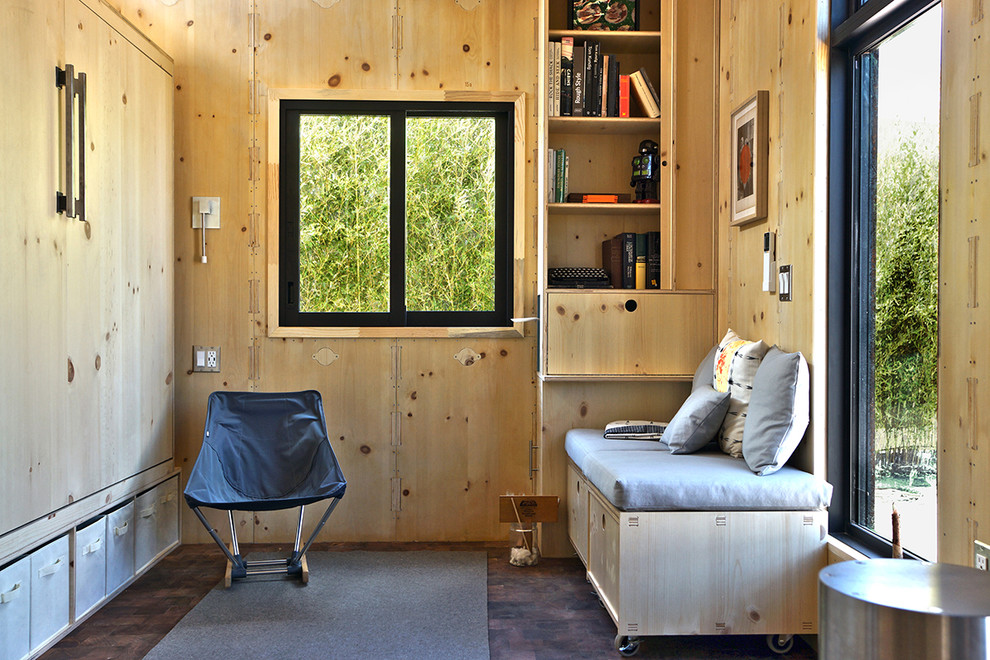 Foto di un piccolo soggiorno minimal aperto con stufa a legna, cornice del camino in metallo, nessuna TV, libreria, pareti beige, parquet scuro e pavimento marrone
