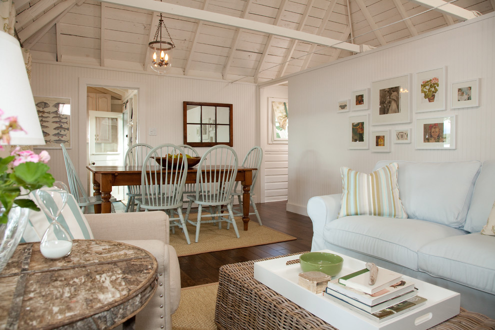 На фото: гостиная комната в морском стиле с белыми стенами и синим диваном
