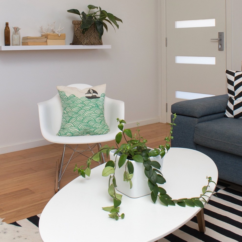 Immagine di un soggiorno minimal di medie dimensioni e chiuso con pareti bianche e pavimento in bambù