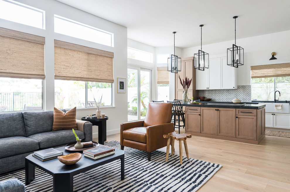 This is an example of a classic open plan living room in San Diego with white walls, light hardwood flooring and beige floors.