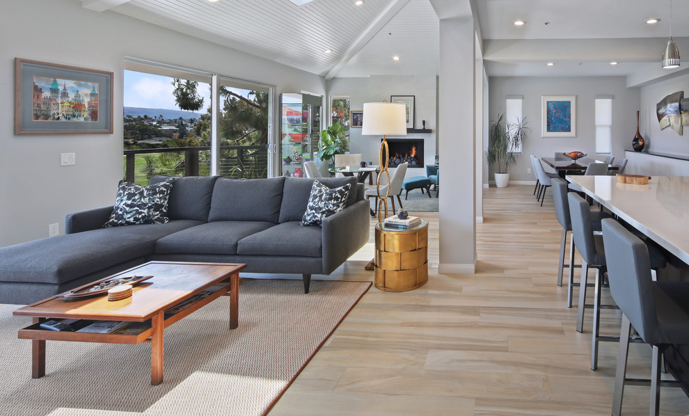 Foto di un soggiorno design di medie dimensioni e aperto con pareti grigie, pavimento in gres porcellanato, camino classico e pavimento beige