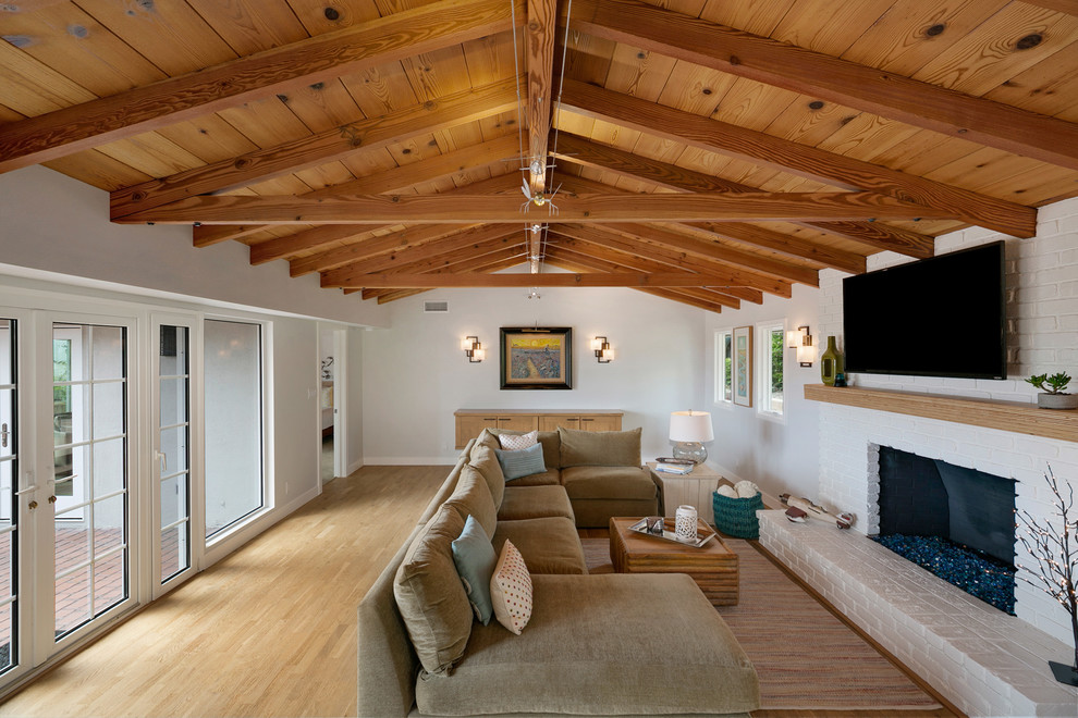 Photo of a medium sized midcentury living room in Orange County with light hardwood flooring, a standard fireplace, a brick fireplace surround and a wall mounted tv.