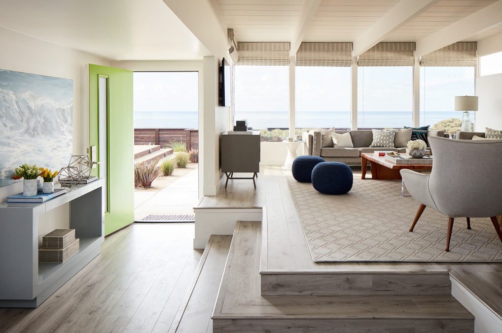 Immagine di un soggiorno minimalista aperto con pareti bianche, pavimento in legno massello medio e pavimento grigio