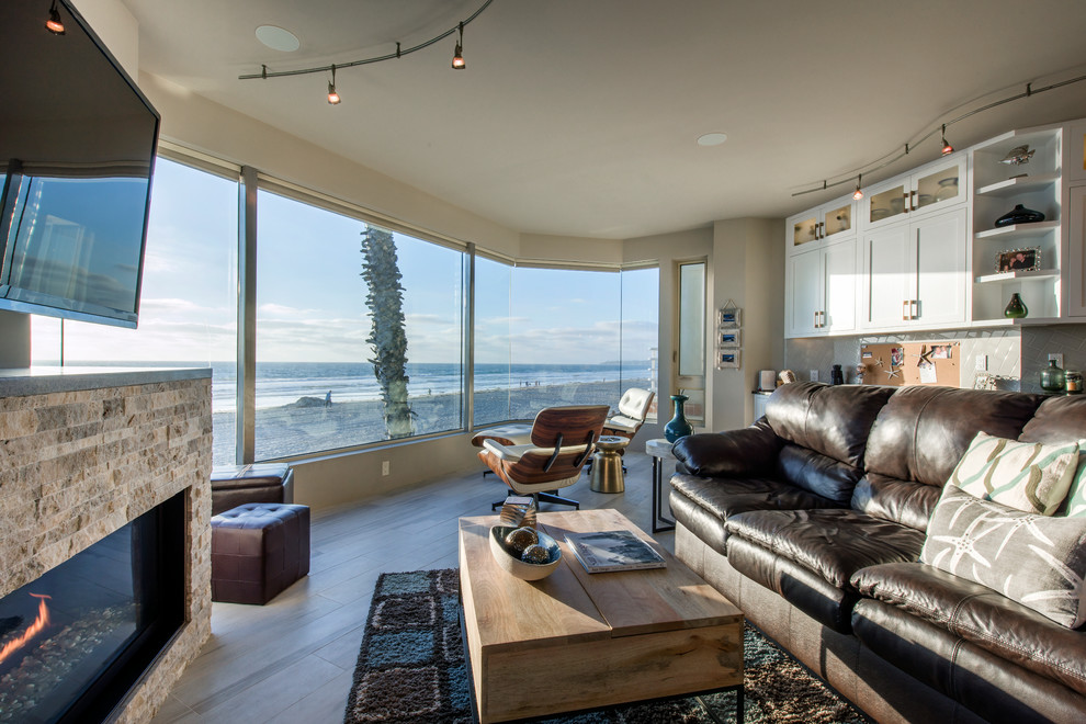 Offenes, Mittelgroßes Modernes Wohnzimmer mit beiger Wandfarbe, hellem Holzboden, Kamin, Kaminumrandung aus Stein und TV-Wand in San Diego