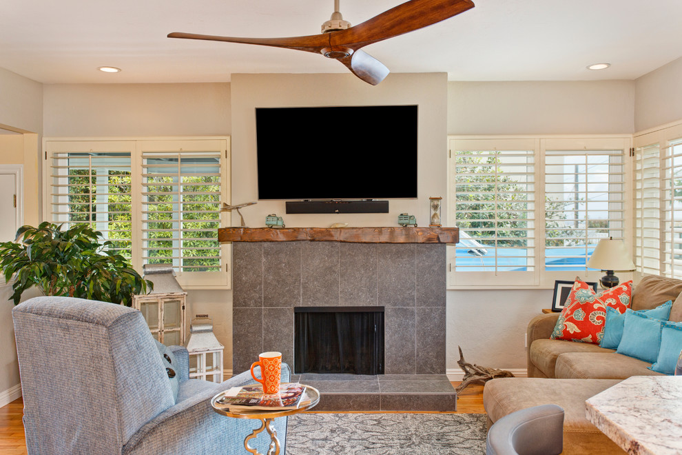 Mid-sized transitional formal and open concept medium tone wood floor living room photo in San Diego with gray walls, a standard fireplace, a tile fireplace and a wall-mounted tv